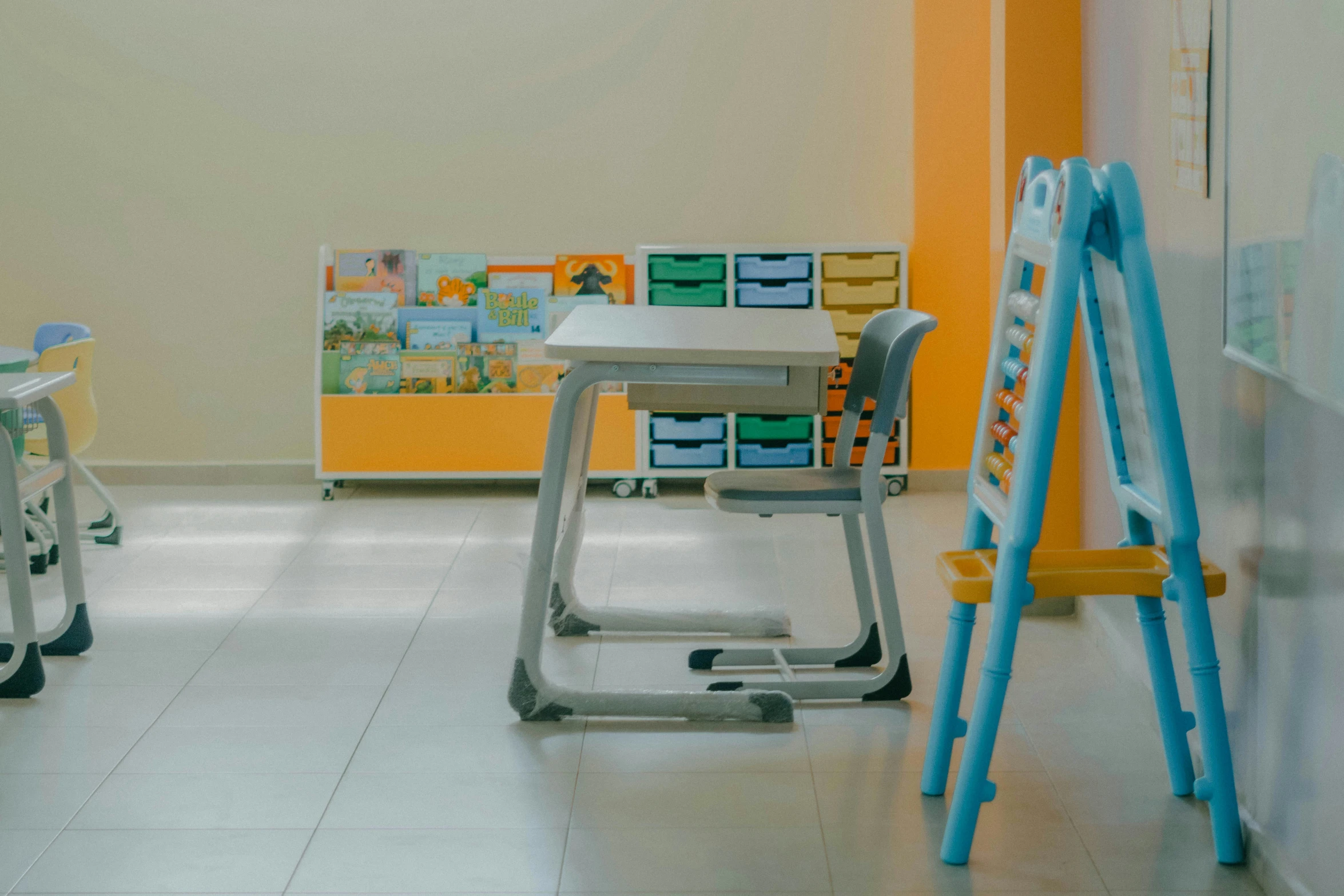 an empty room with two different sized wooden children's chairs