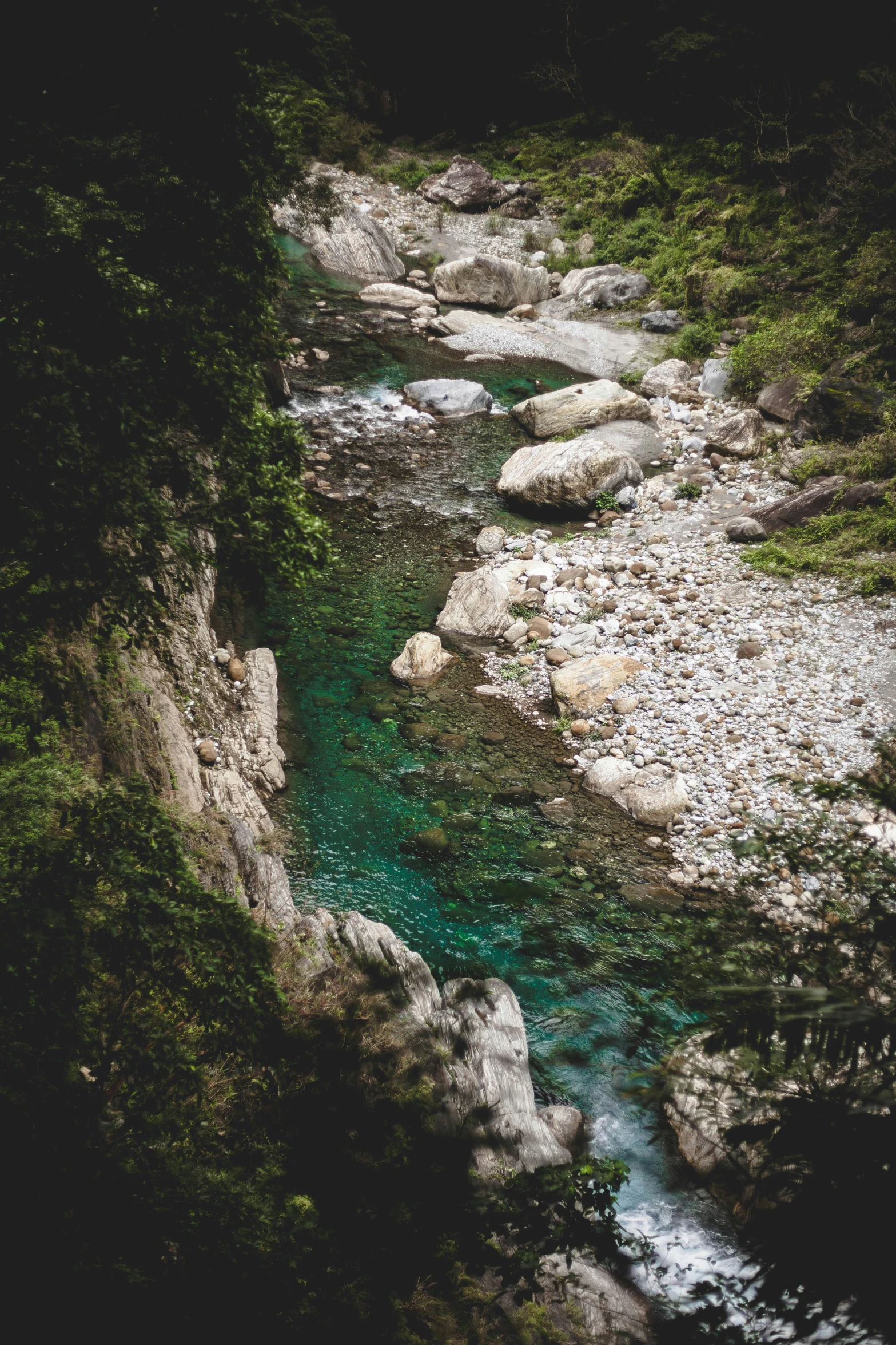 a blue river running through the middle of a forest