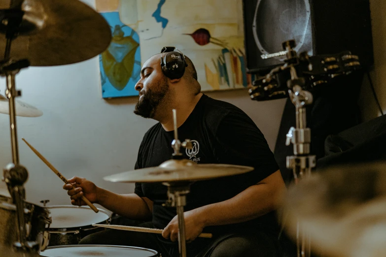 a man with headphones is playing the drums