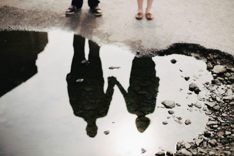 two people stand in front of a pot hole