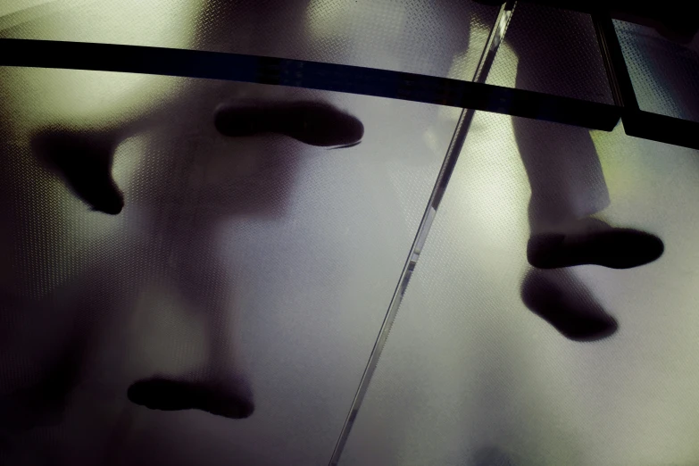 an umbrella reflecting a person's face on a clear window