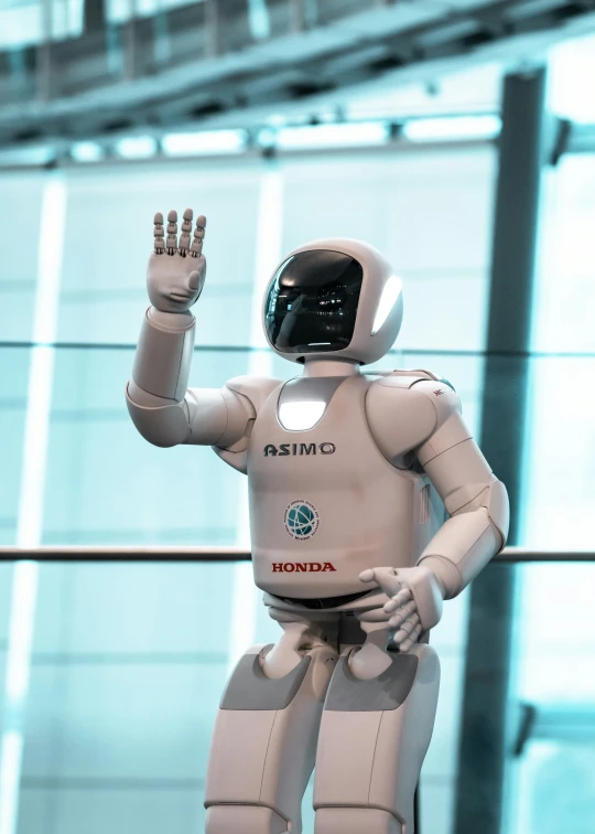 a robot waving while standing in front of a building