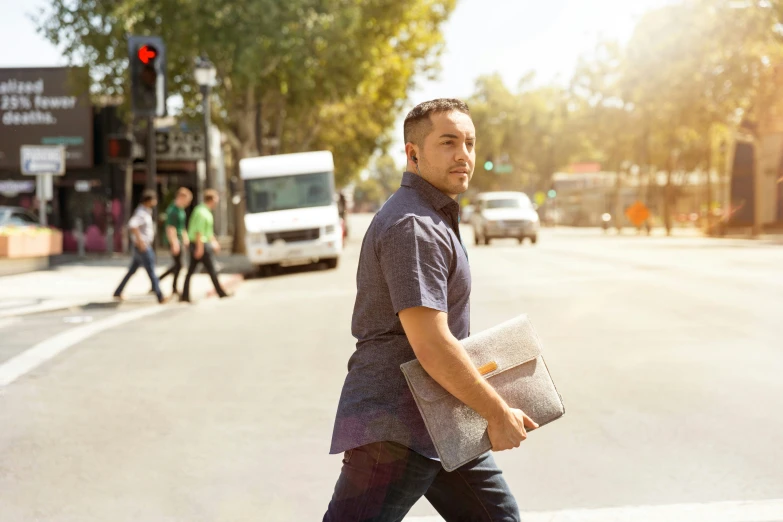 a man walking down a street holding a bag