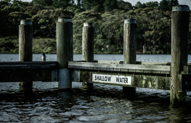 there is a water way and some wooden poles on the side