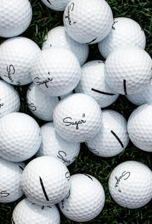 a big bunch of golf balls sitting on the ground