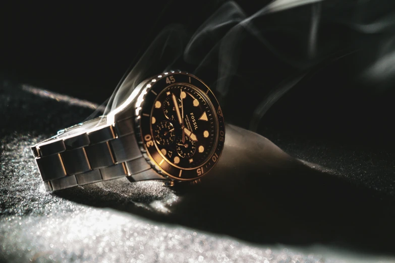 a watch sitting on top of a table next to its shadow