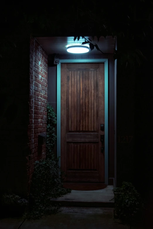 a door with a light on lit up in the night