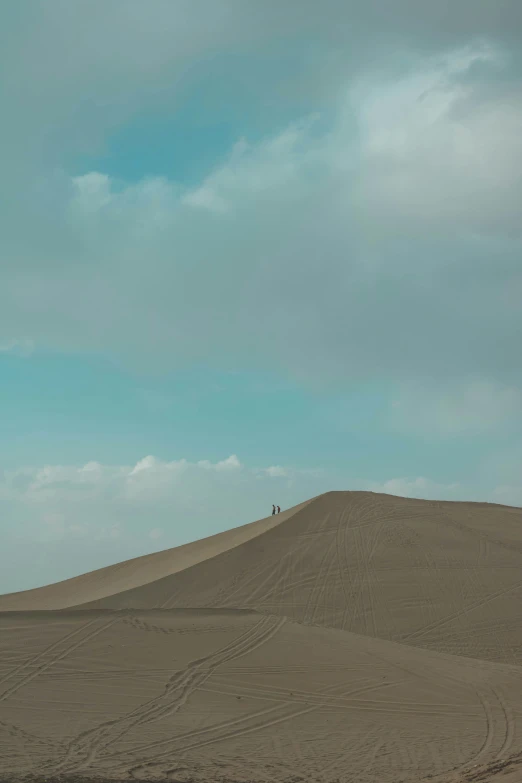 a man on a hill flying a kite