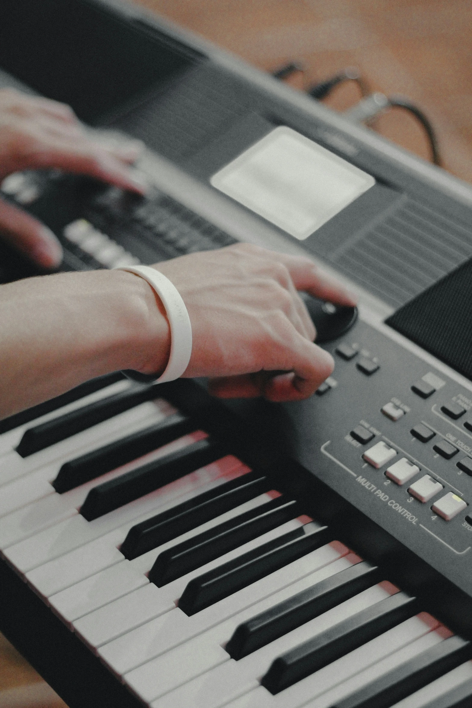 someone playing an electronic organ keyboard on a wooden table