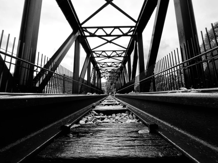 a rail bridge seen through a set of railroad tracks