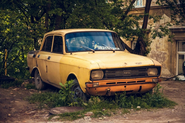 an old yellow truck parked outside a stone building