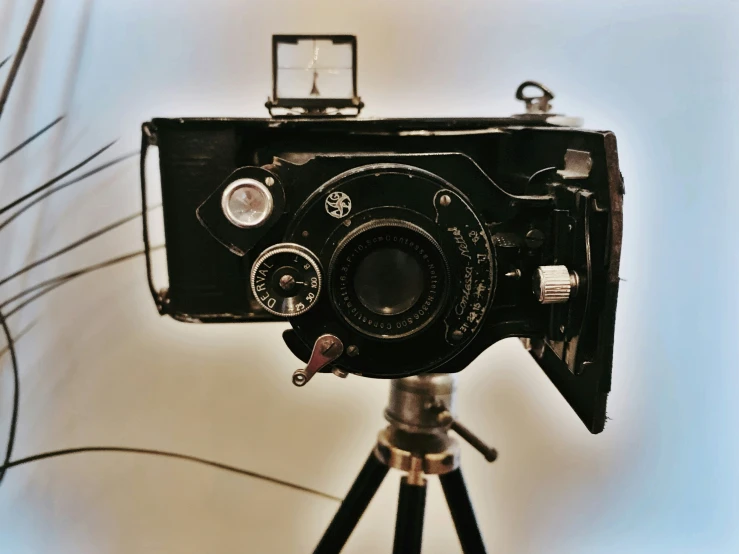 the old fashioned camera is placed on a tripod