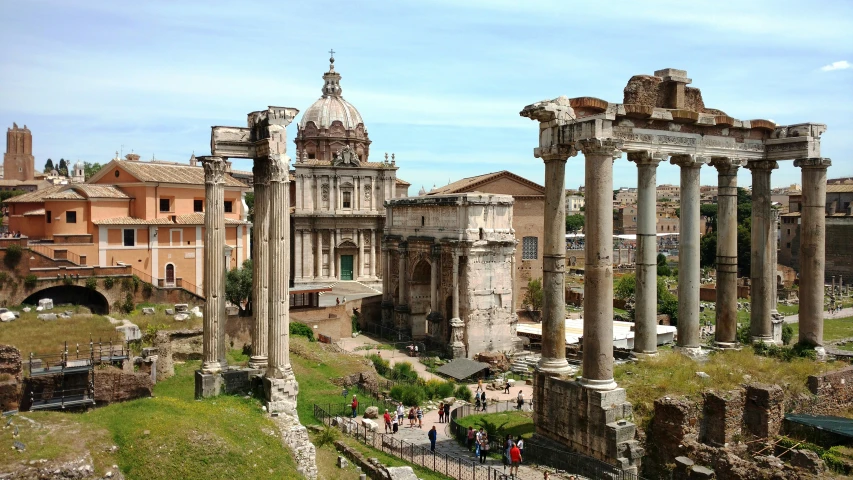 people are walking around in front of ancient ruins