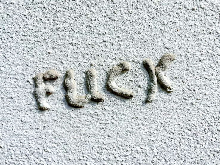 a word made out of foamy water sitting on top of the sand