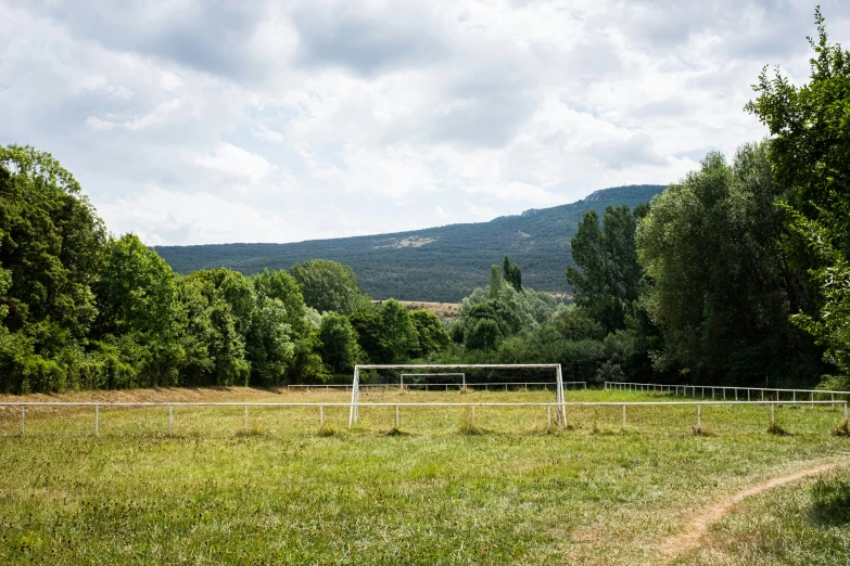 the white fence line is in front of a grassy field