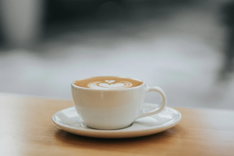 cup with an object in the middle sits on a wooden table