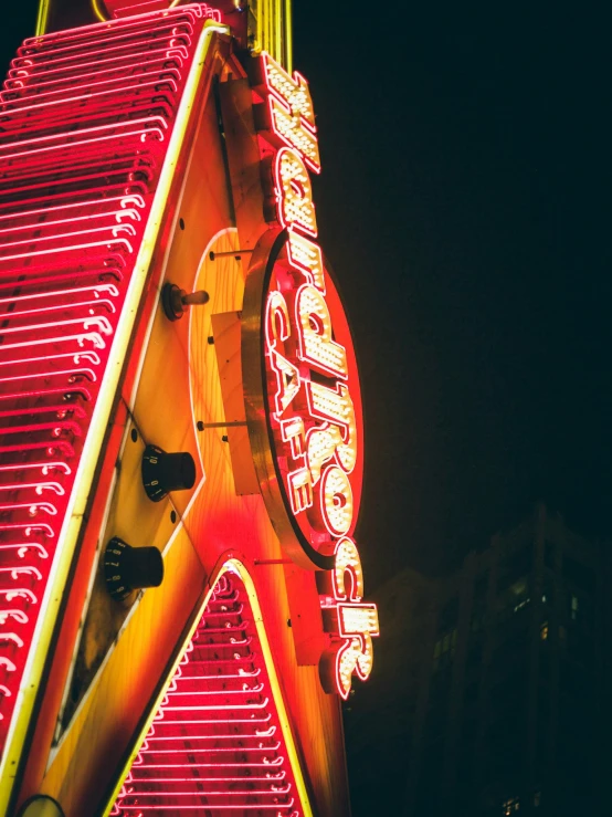 a brightly lit neon sign on the side of a building