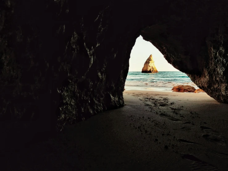 a sandy beach with a boat sitting in the water