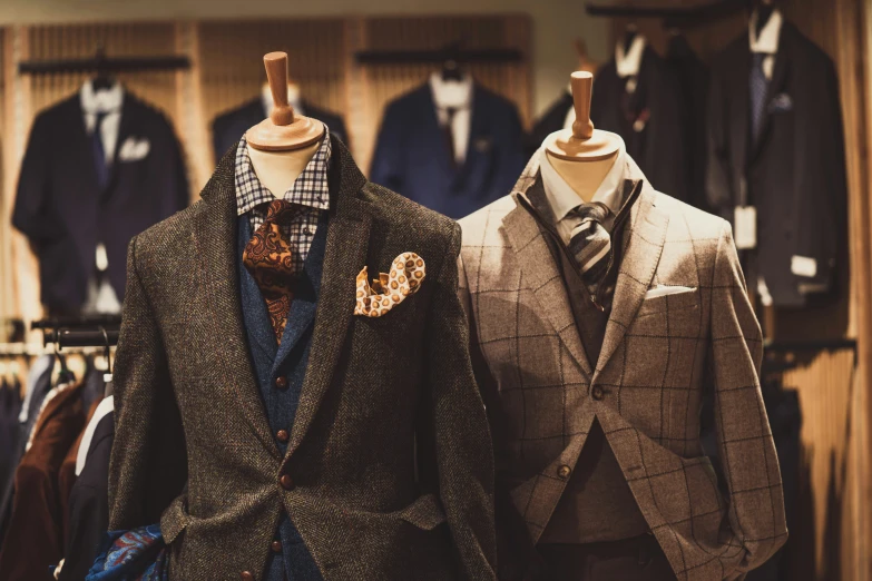 two suits and tie pieces on hangers in a store