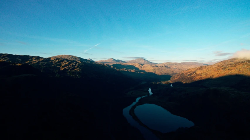 a landscape view looking down on a river in the middle of the mountain range