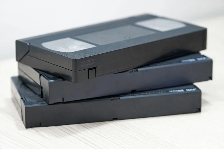 three small black boxes sitting next to each other on top of a white surface