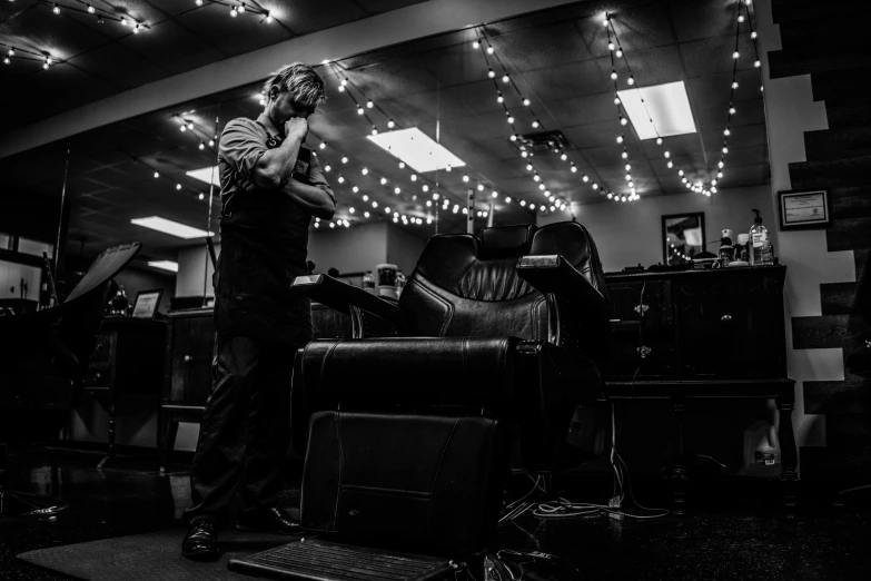 a barber stands in a room filled with lights