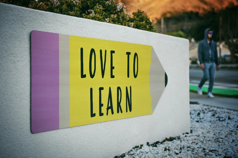 there is a hand painted sign reading love to learn