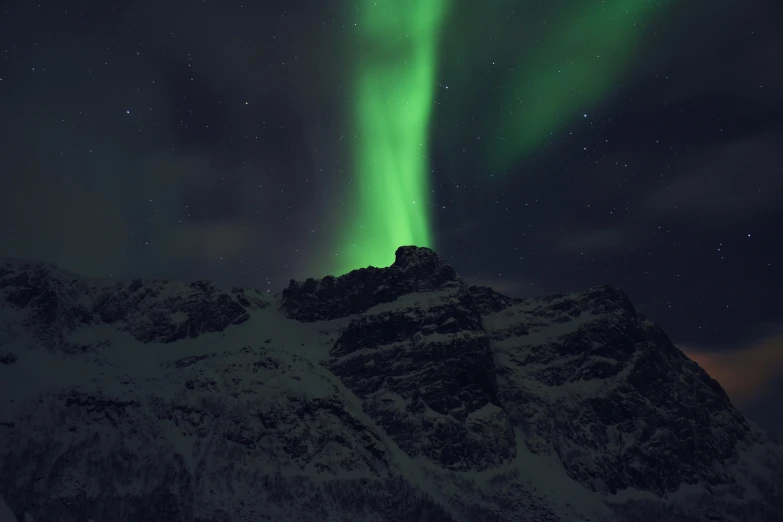 an aurora aurora rising above the mountains and the sky
