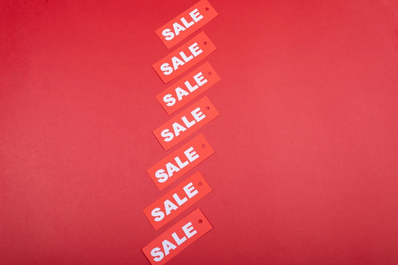 a red sign with sale words sitting next to each other
