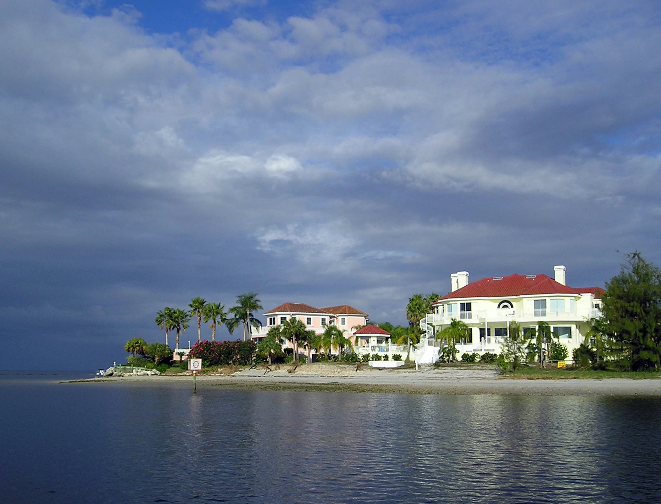 a white building on the shore of a calm body of water