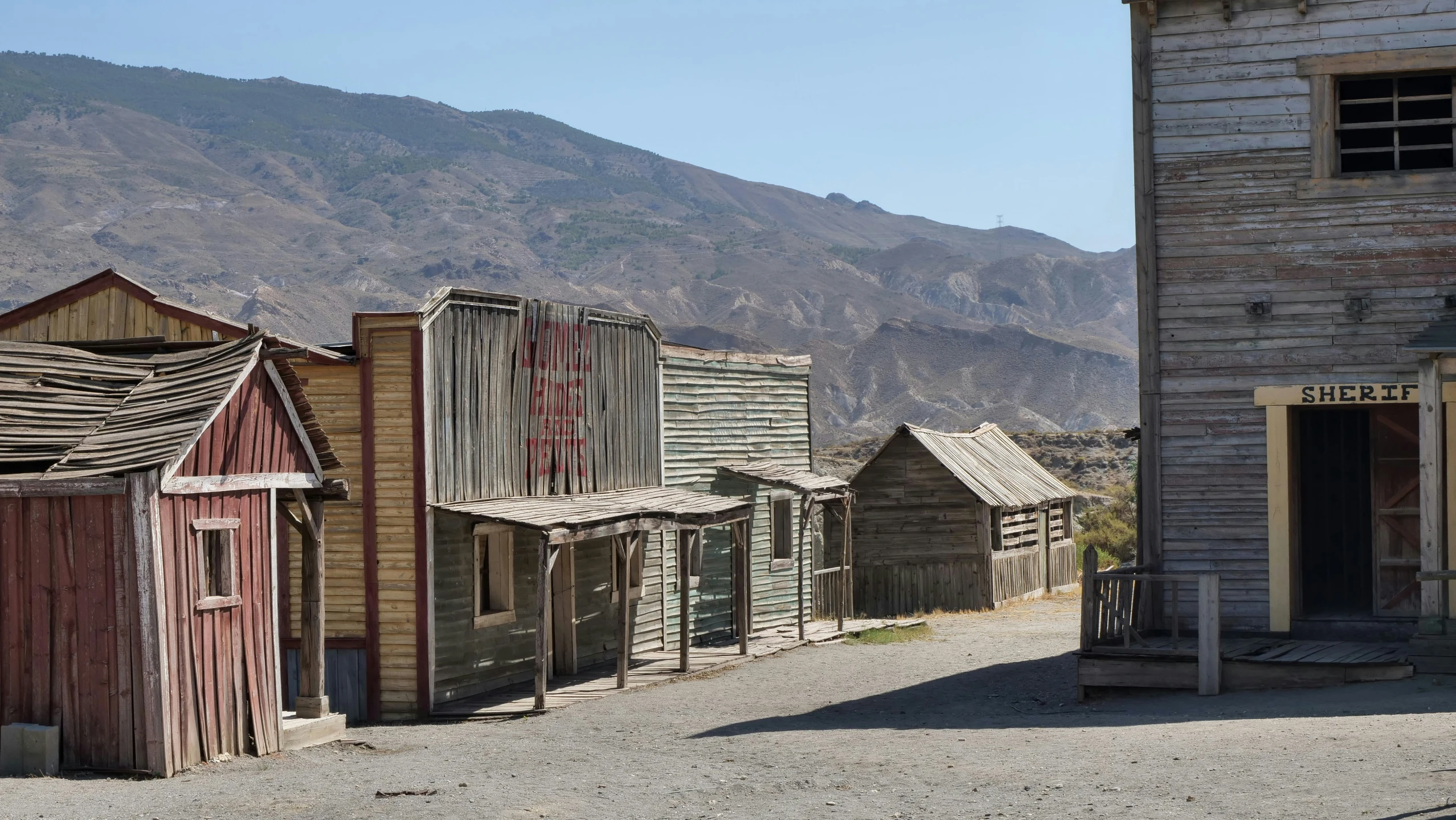 abandoned building with brown siding and mountains in background