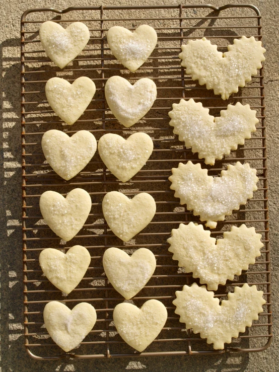 heart shaped cookies with sugar icing on a cooling rack