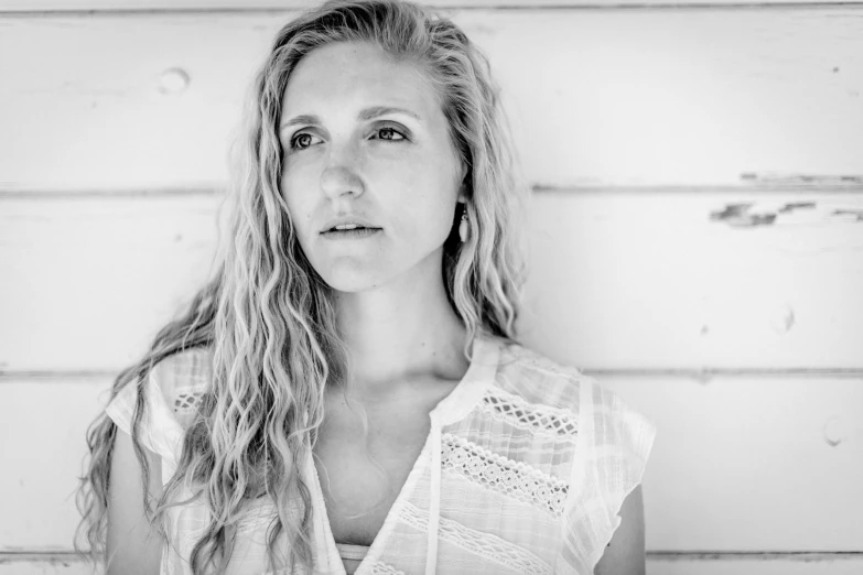 black and white pograph of woman in front of wall