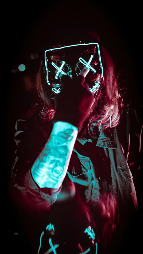 a woman in a red light mask holding a phone