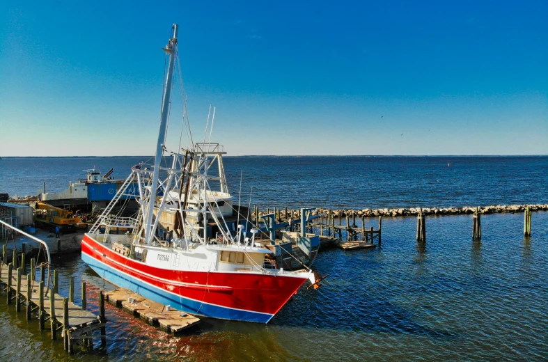 a fishing boat docked at the end of the pier