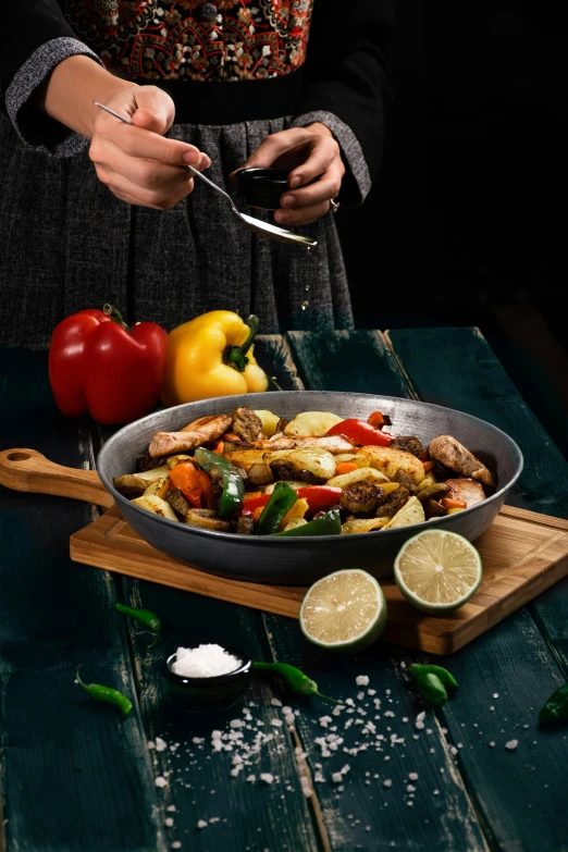 there is someone spooning food in the pan on the table