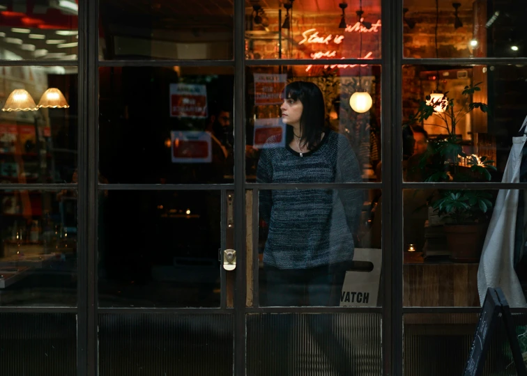 a woman looking through the window of a restaurant