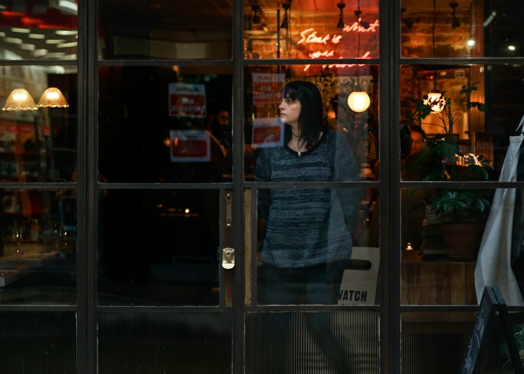 a woman looking through the window of a restaurant