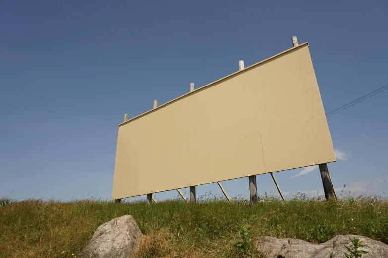 large billboard on top of a rocky hill with sky in the background