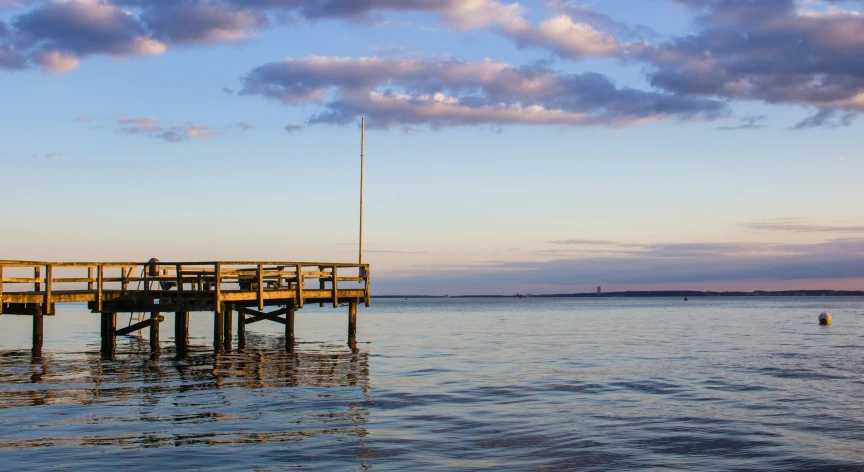 a boat is sitting in the water by a dock