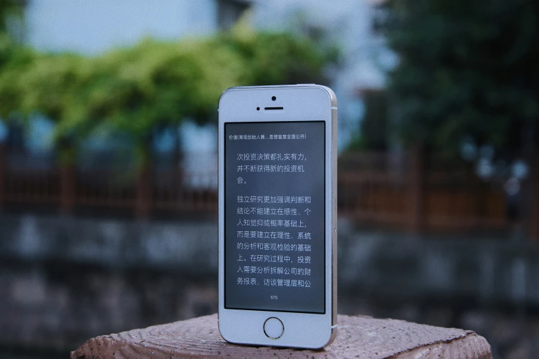 an iphone sitting on top of a wooden log