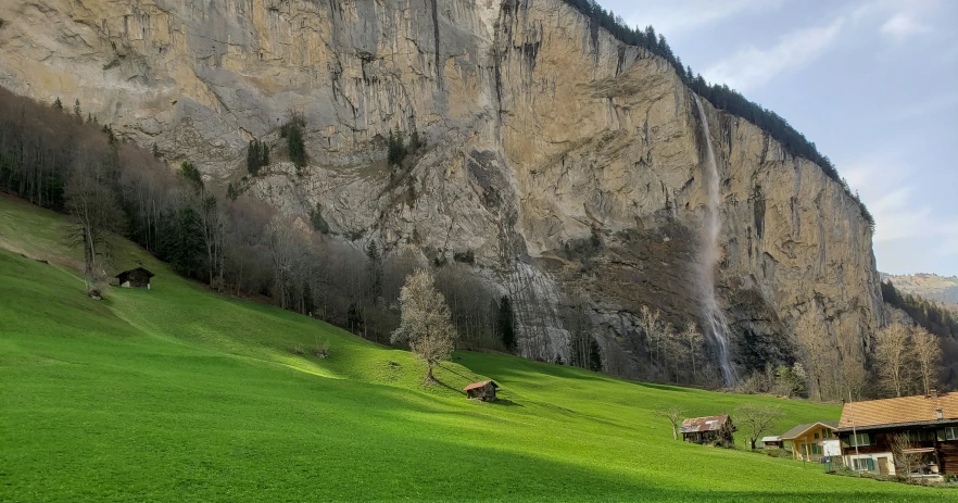 a mountain side house near a big rocky cliff