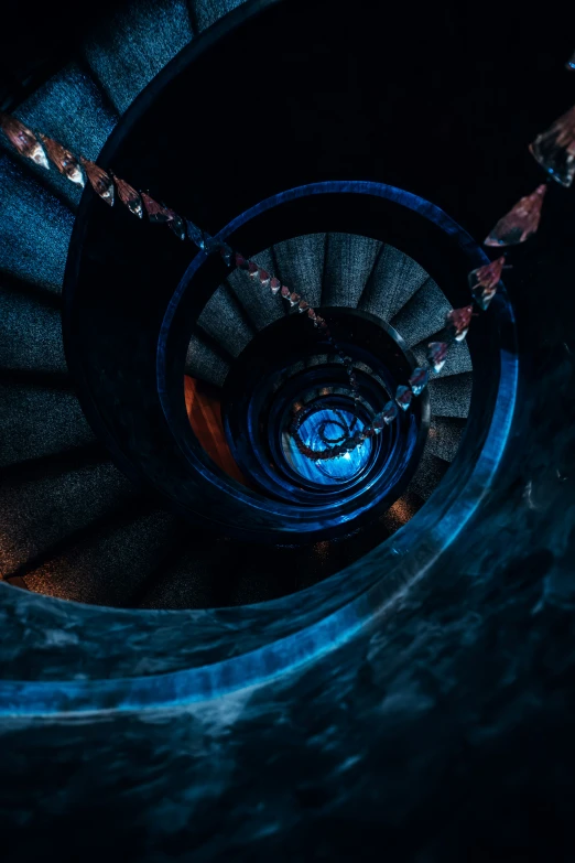 a spiral staircase is lit up in the dark