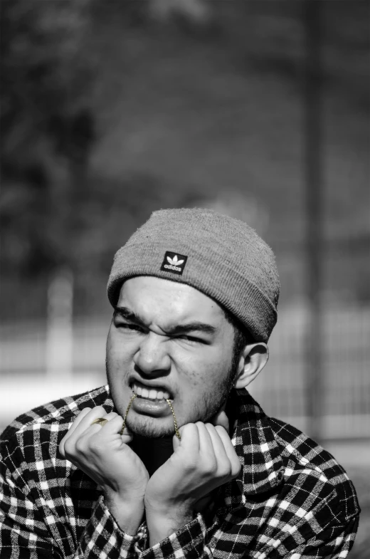 a man eating a  dog while wearing a hat