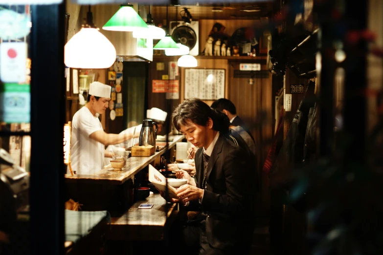 two men at a restaurant bar checking cellphones