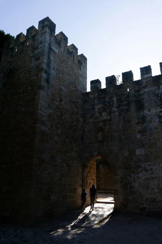 two people standing in front of the entrance to a castle