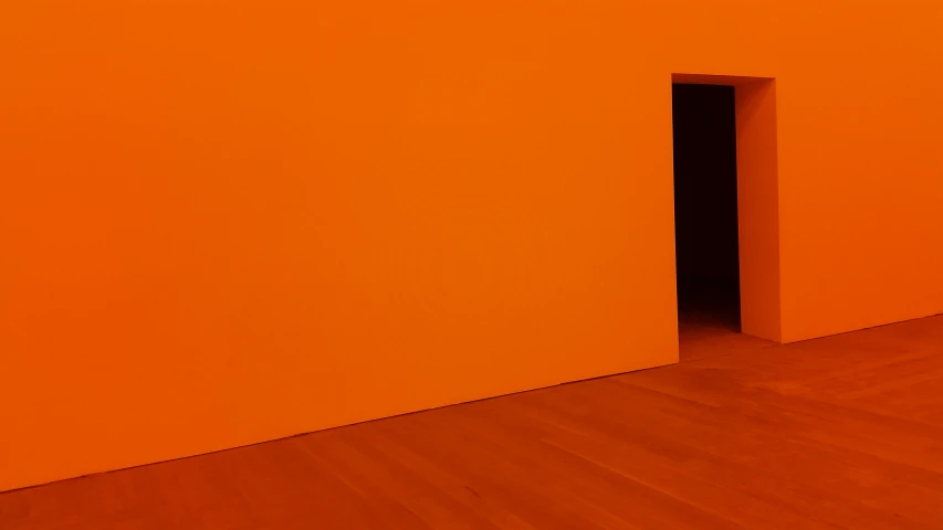 an orange room with a small black door