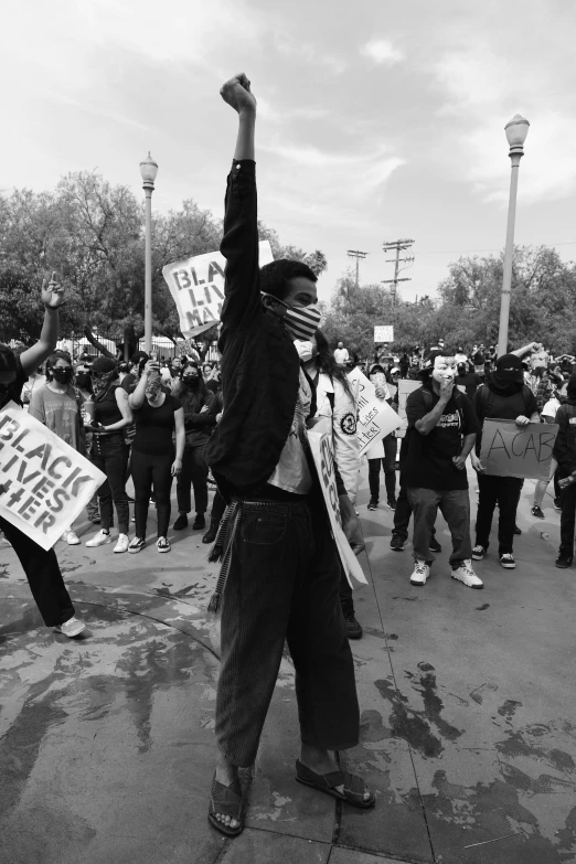 people holding protest signs at a demonstration outside of a building