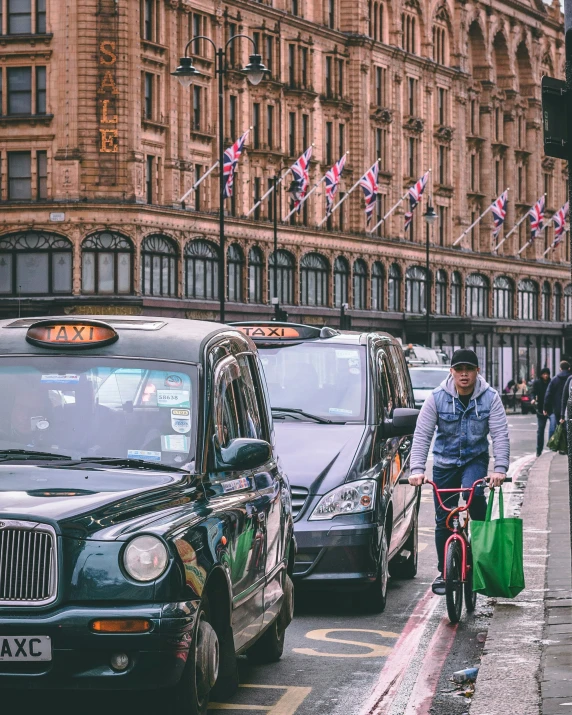 a man riding a bike down the street next to taxis