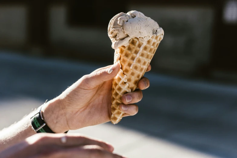 someone is holding out an ice cream cone in their hand